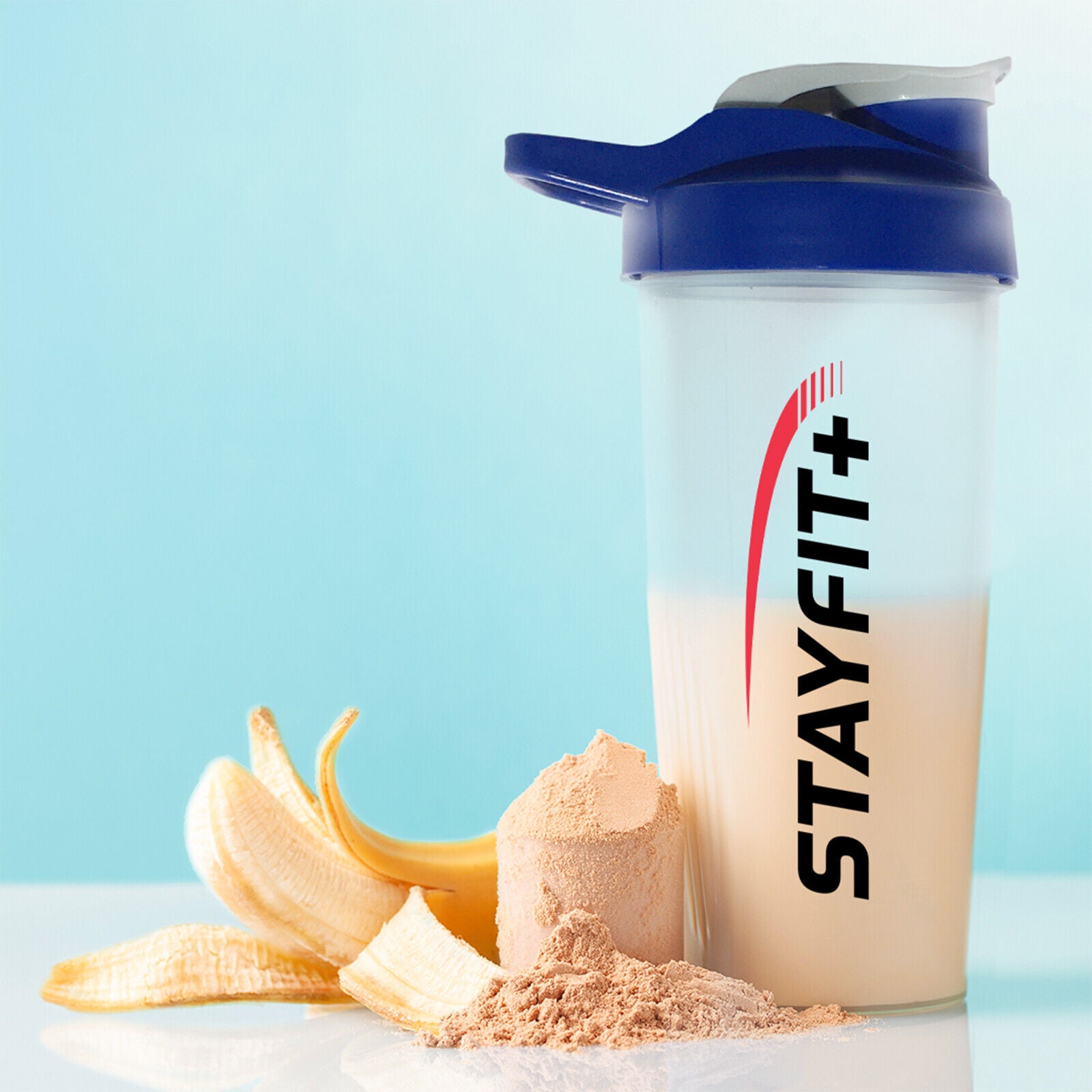 Protein shaker bottle next to a pile of powder and fruit