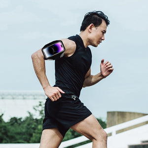 Male runner running up stairs with a fitness armband around his arm