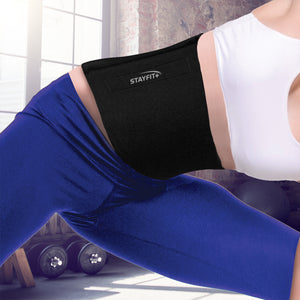 Female athlete stretching in a gym with a closeup of a slimmer belt