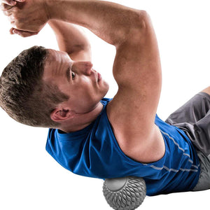 Male athlete rolling out his back on a massage ball