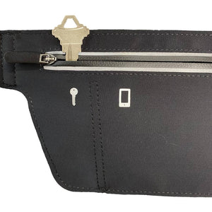 One side of a black slim waist pack with a key sticking out of the zippered pocket on the side for keys